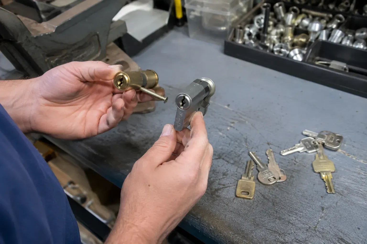 Hands comparing detached lock cylinders beside loose keys on a workbench. — Broken Key Extraction, Innisfil